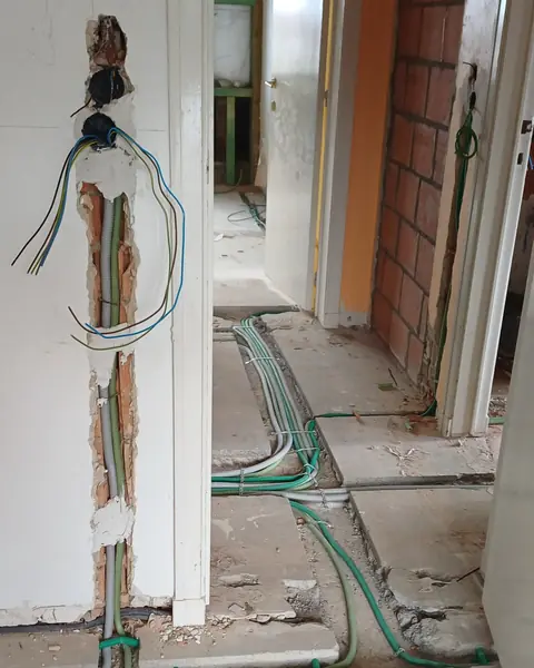 Saignée dans un mur de couloir, gaines électriques encastrées pendant une rénovation